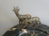 a statue of a deer and a baby deer on top of a marble table