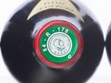 two bottles of wine are sitting side by side on a white surface