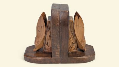 a wooden bookend with a book and a bird on it