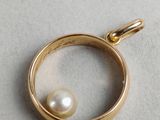 a close up of a gold ring with a pearl in it