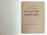 un livre ouvert posé sur une table blanche, près d'un mur blanc