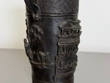 a black vase with a dragon on it on a table