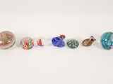 a group of five glass beads on a white surface