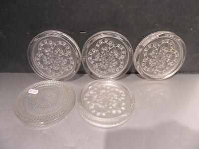 quatre sous-verres en verre posés les uns à côté des autres sur une table