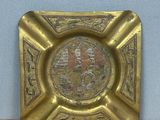 a gold plate with a picture on it on a shelf
