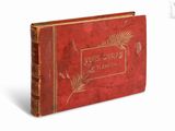 un vieux livre à la couverture rouge posé sur une surface blanche
