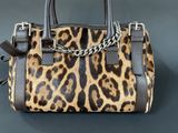 a close up of a leopard print handbag on a table
