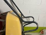 a yellow wheelbarrow with a black handle on the floor
