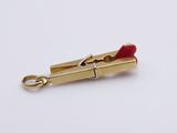 a close up of a red lipstick on a gold plated clasp
