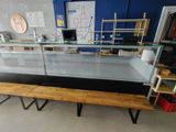 une vitrine en verre avec un banc en bois devant