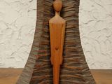 wooden sculpture of a man standing in front of a wall