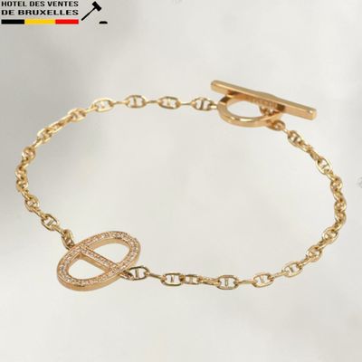 a close up of a gold bracelet with an infinity charm