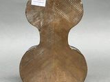 a wooden sculpture of a guitar on a gray surface