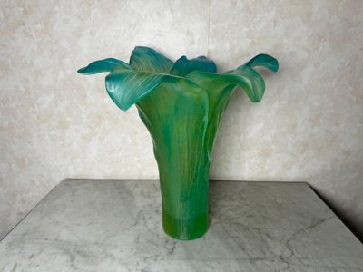un vase vert posé sur une table en marbre