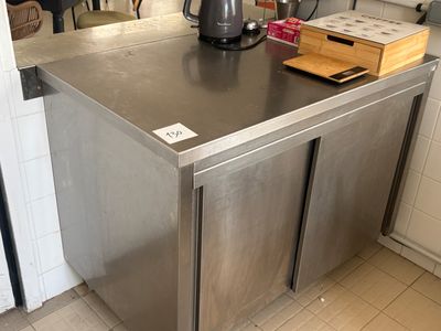 un îlot de cuisine en acier inoxydable au milieu de la cuisine