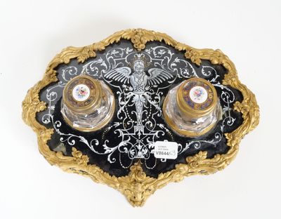 two salt and pepper shakers sitting on a black and gold plate