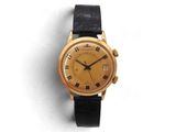 une image d'une montre en or avec des chiffres romains sur le cadran