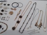 many different necklaces and bracelets laid out on a table