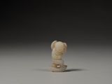 a small ivory figurine of a monkey on a rock