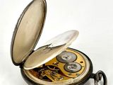 a pocket watch that is open on a white surface