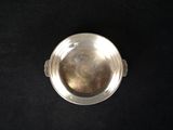 an old silver bowl on a black surface with a black background