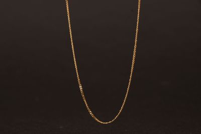 un collier à chaîne en or avec un fermoir en diamant sur fond noir