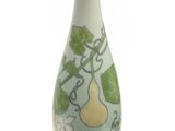 un vase vert orné de poires sur fond blanc