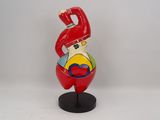 figurine of a clown in a red suit with a hat on a black base