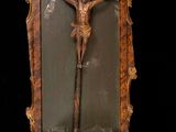 a statue of jesus on the cross in a glass case