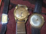 trois montres sont posées les unes à côté des autres sur un tissu rouge