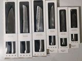 several different types of kitchen knives in a box on a table