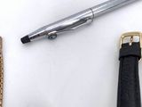a pen, a watch, and a watch band on a table