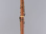 a close up of a wooden clarinet on a clear surface