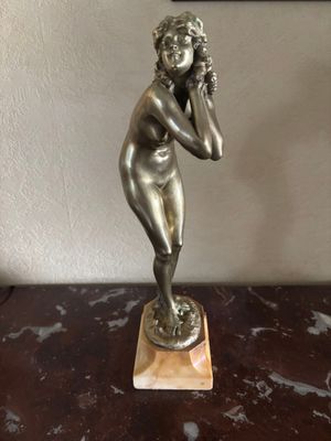 statue d'une femme parlant au téléphone portable, posée sur une table en marbre