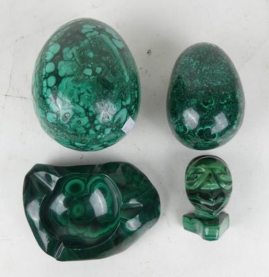 three pieces of green marble sitting next to each other on a table