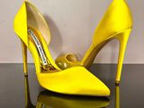 a pair of yellow high heels on a black surface