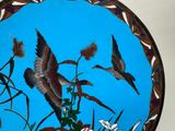 two birds that are flying over some flowers