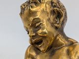 a gold statue of a boy holding a baby