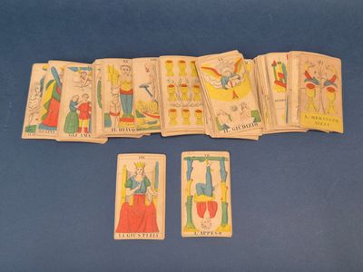 Plusieurs cartes de tarot sont disposées sur une surface bleue