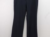 un pantalon noir suspendu à un cintre devant un mur blanc