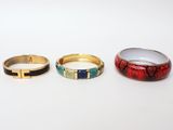 three different colored rings sitting next to each other on a white surface