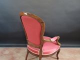 a pink chair that is sitting in a room