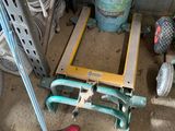 a pile of assorted items and tools in a garage