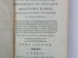 an open book on a white surface with a black and white title