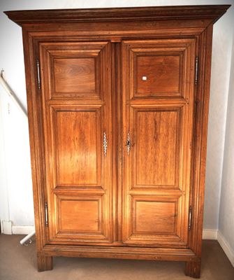 a wooden armoire in the corner of a room