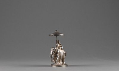 an image of a silver candle holder with a statue on it