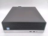 the hp desktop computer is on a white surface with a blue sticker on it