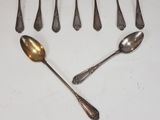 six spoons and two spoons are arranged on a white surface