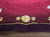 a bed with a red and purple comforter with elephants on it