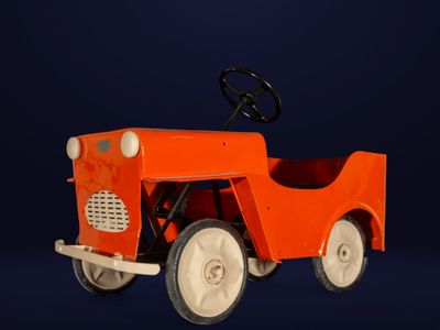une petite voiture orange avec un volant, sur fond bleu